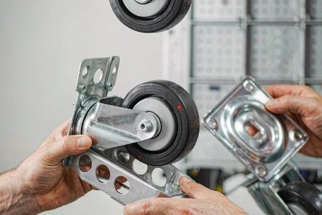 Workers assembling swivel caster wheels with steel top plates at Xingteng factory